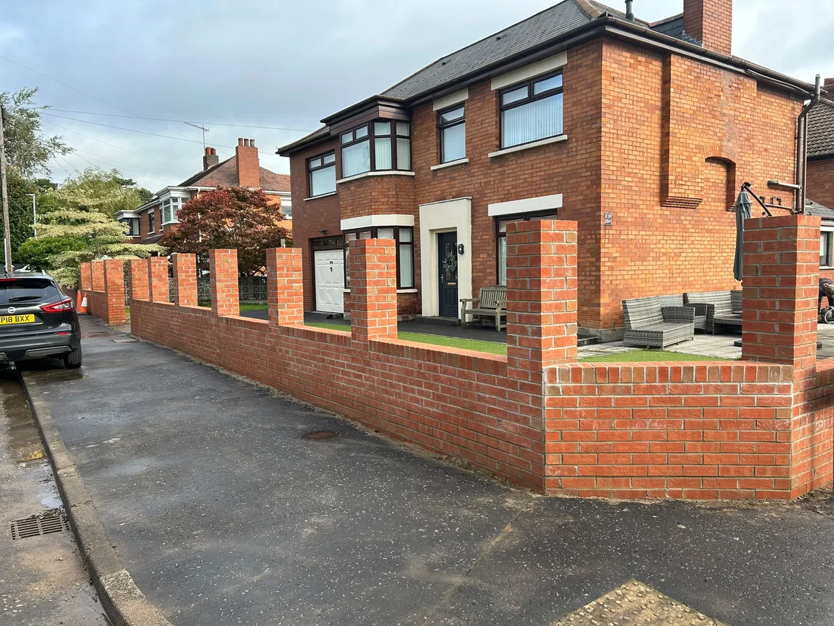 New brick boundary wall and pillars during construction before the timber panels and coping were fitted