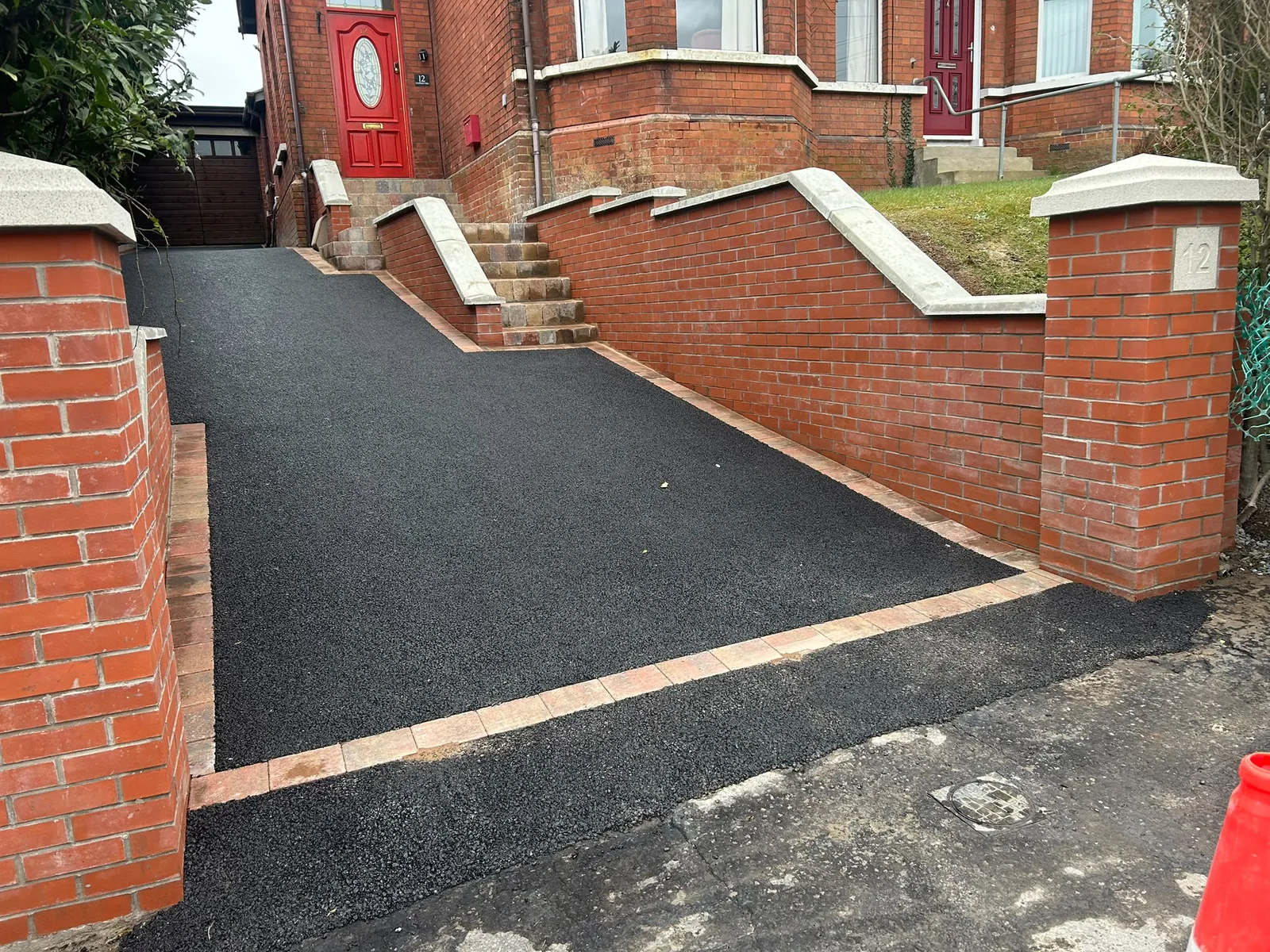 Driveway project with brick retaining walls, pale coping and paved entrance steps to the front door